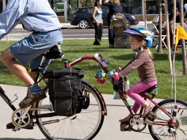 一对父母和他们的孩子骑双人自行车